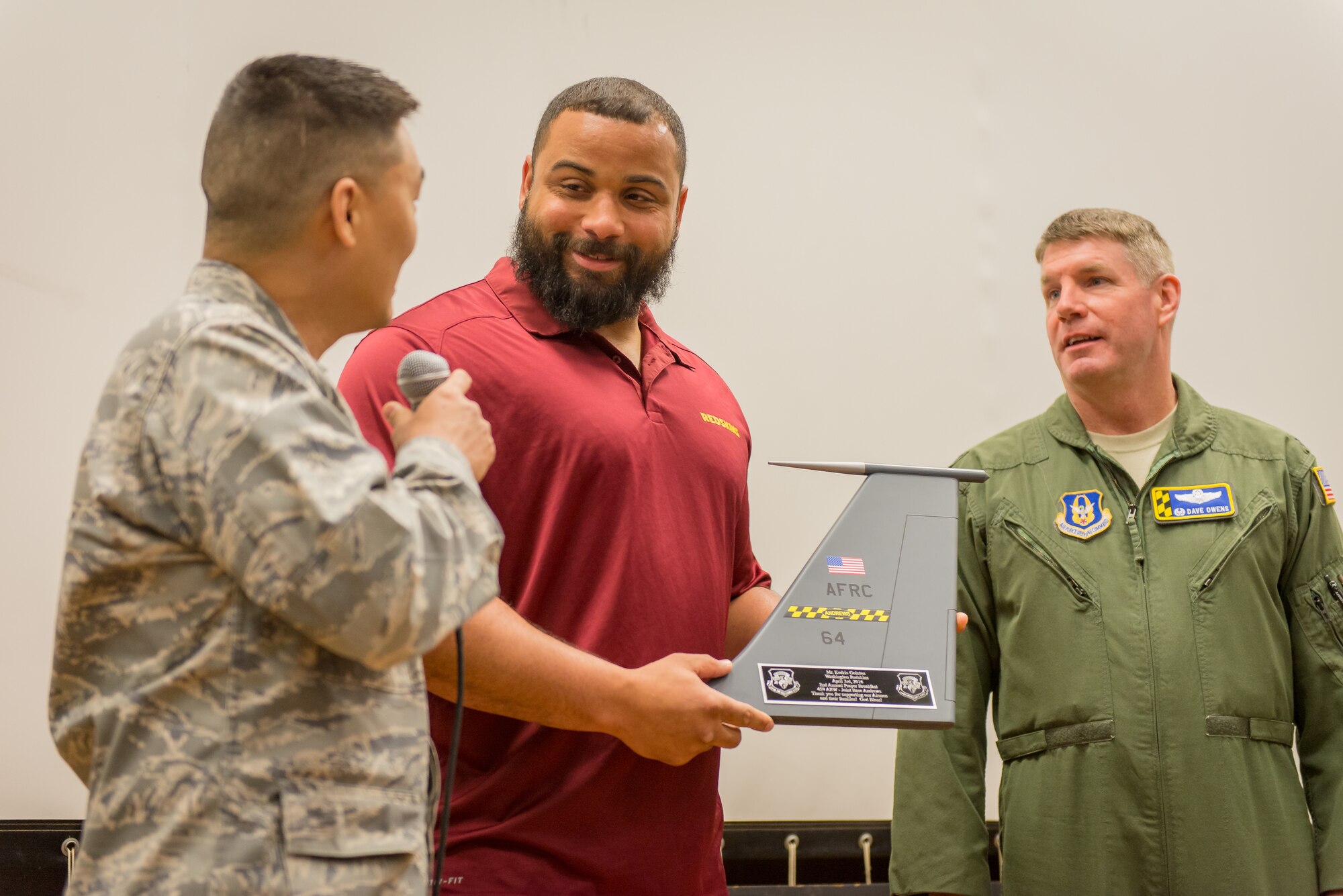 Kedric Golston, a professional football player with the Washington Redskins, accepts a token of appreciation from Col. David Owens, 459th Air Refueling Wing commander, and Maj. Joshua Kim, head chaplain for the 459th ARW, for being the guest speaker at the wing’s annual Prayer Breakfast on April 3, 2016 at Joint Base Andrews, Md. Golston spoke about the importance of his faith in his success to a group of more than 150 reservists from the 459th ARW during the annual breakfast.
