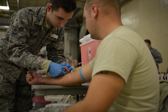 Airman 1st Class Anthony Wroblewski, 934th Aeromedical Staging Squadron, draws blood from an Airman's arm. Members from the 934th Airlift Wing proceeded through a mass processing line at the Minneapolis-St. Paul Air Reserve Station in order to complete their annual medical requirements. (U.S. Air Force photo by Staff Sgt. Corban D. Lundborg/Released)