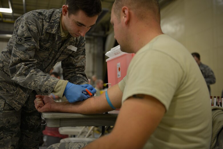 Airman 1st Class Anthony Wroblewski, 934th Aeromedical Staging Squadron, draws blood from an Airman's arm. Members from the 934th Airlift Wing proceeded through a mass processing line at the Minneapolis-St. Paul Air Reserve Station in order to complete their annual medical requirements. (U.S. Air Force photo by Staff Sgt. Corban D. Lundborg/Released)