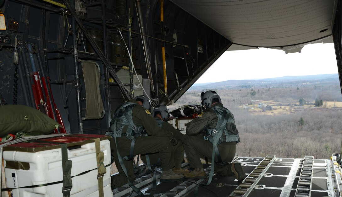 Loadmasters assigned to the 103rd Airlift Wing prepare to drop a bundle out the back of a C-130 Hercules over the 439th Westover Air Reserve Base, Chicopee, Mass. The Flying Yankees, in coordination with the 439th, are conducting a Low Cost Low Altitude air drop. LCLA airdrops enable the C-130 to efficiently drop supplies or any crucial materials required by those on the battlefield at a below average altitude to lessen the threat to
whomever may be receiving the care package. (U.S. Air National Guard photo by Senior Airman Emmanuel Santiago)