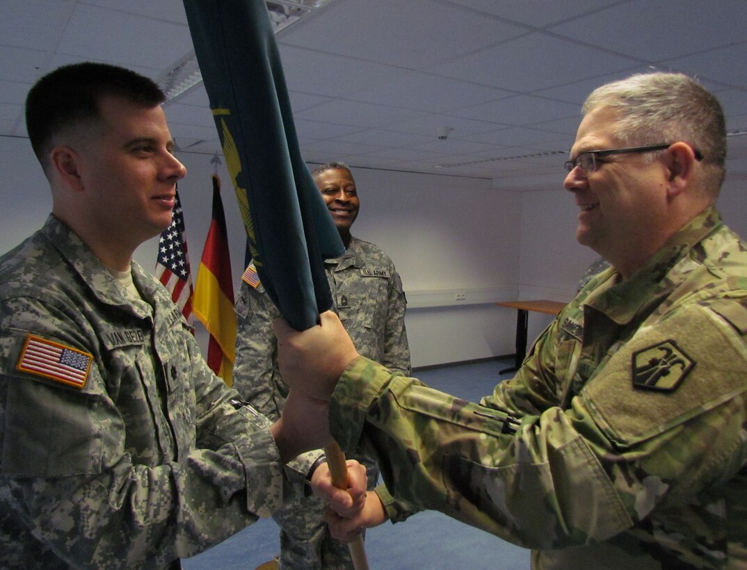 Lt. Col. Edward W. Van Giezen, incoming commander of the 7th Intermediate Level Education Detachment, receives the unit’s colors from Kevin M. Sanders, the deputy commanding officer of the 7th Mission Support Command, Saturday, April 2, 2016 during the change of command ceremony. (Photo by Chaplain Lt. Col. Brian Harki, 7th Mission Support Command)