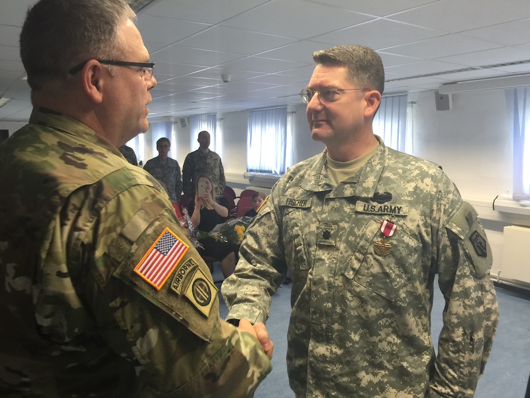 Lt. Col. Joel D. Fischer, outgoing commander of the 7th Intermediate Level Education Detachment, shakes hands with Col. Kevin M. Sanders, deputy commanding officer of the 7th Mission Support Command, Saturday, April 2, 2016 after the 7th ILE’s change of command ceremony. (Photo by Chaplain Lt. Col. Brian Harki, 7th Mission Support Command)