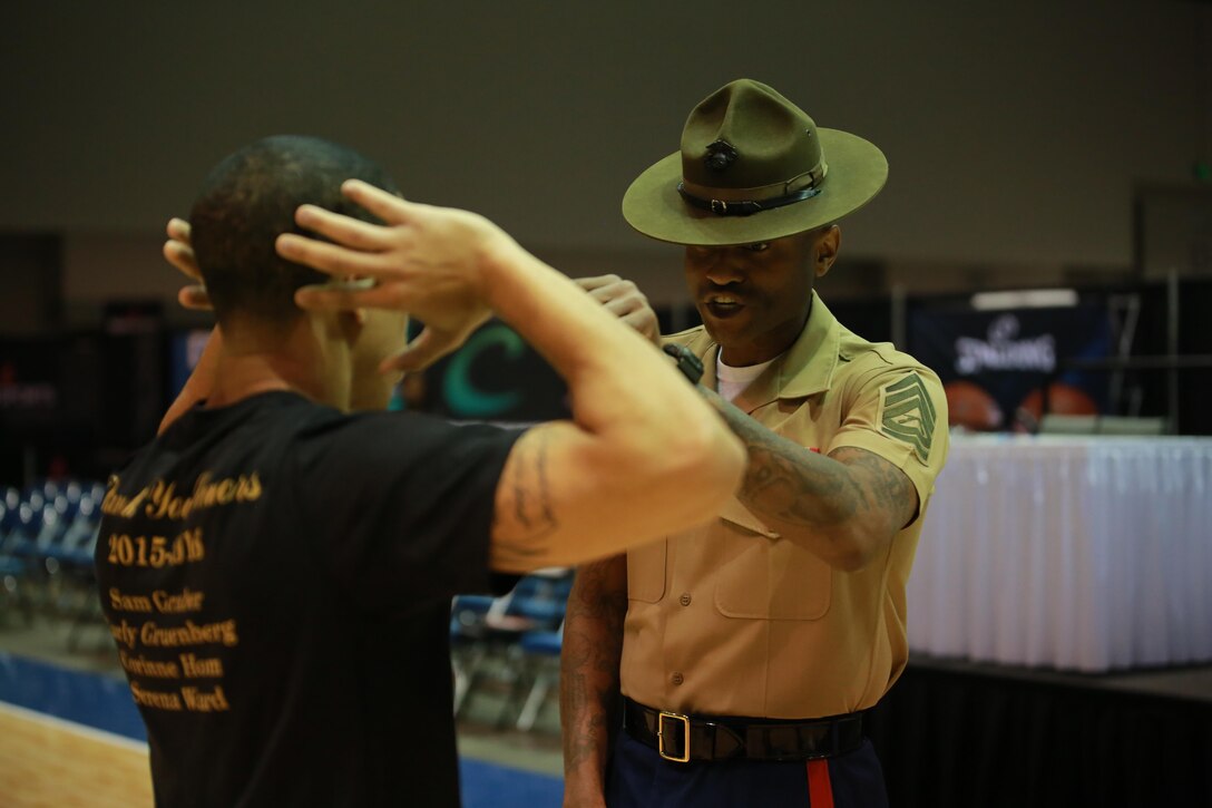 Gunnery Sgt. Chad Williams corrects Jordan McCann during the Wake Up and Workout at the 2016 Women's Basketball Coaches Association (WBCA) in Indianapolis, April 3. The Wake Up and Workout gives the coaches an opportunity to train with the Marines, and learn valuable lessons in leadership and teamwork to take back to their players. Williams is a Sergeant Instructor at Marine Corps Officer Candidate School, and McCann is the Assistant Women's Basketball Coach at Hamilton College.