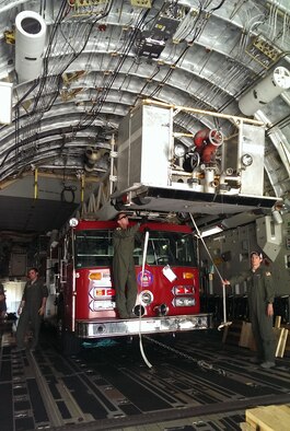 A a City of Coral Gables firetruck is loaded into the back of a Joint Base Charleston C-17 Globemaster III at Homestead Air Reserve Base, Fl. April 2.  In this photo, 300th Airlift Squadron loadmasters secure the vehicle before taking the donated fire truck to La Antigua, Guatemala as part of the Denton Cargo Program (Courtesy Photo)