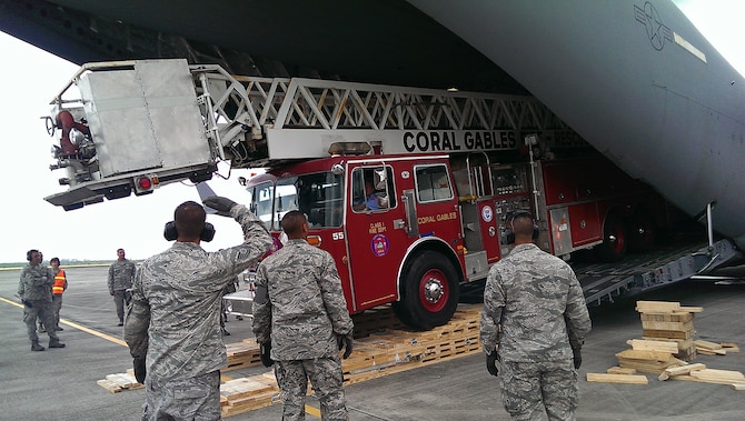 A a City of Coral Gables firetruck is loaded into the back of a Joint Base Charleston C-17 Globemaster III at Homestead Air Reserve Base, Fl. April 2.  Reservists from 300th Airlift Squadron delivered the donated fire truck to to La Antigua, Guatemala as part of the Denton Cargo program. (Courtesy Photo)