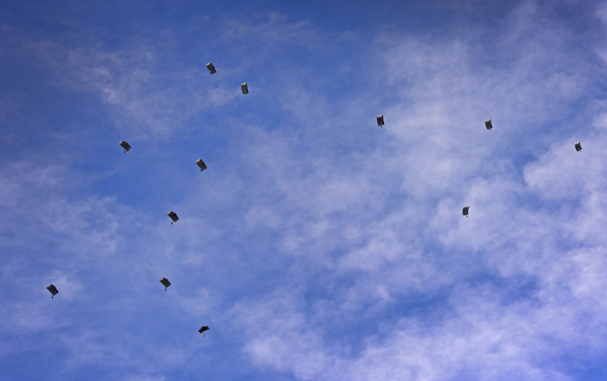 A dozen members of the 26th Special Tactics Squadron parachute down from an aircraft over the flightline March 25, 2016, at Cannon Air Force Base, N.M. Special Tactics Airmen train to maintain operational readiness, able to infiltrate into areas where aircraft cannot land. (U.S. Air Force photo/Staff Sgt. Alexx Pons) 