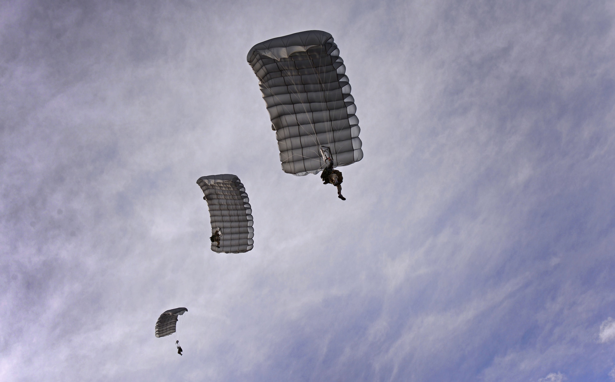 Three members of the 26th Special Tactics Squadron parachute down over the flightline March 25, 2016, at Cannon Air Force Base, N.M. Air Commandos with the 26th STS performed routine practice jumps as part of maintaining operational readiness. (U.S. Air Force photo/Staff Sgt. Alexx Pons) 