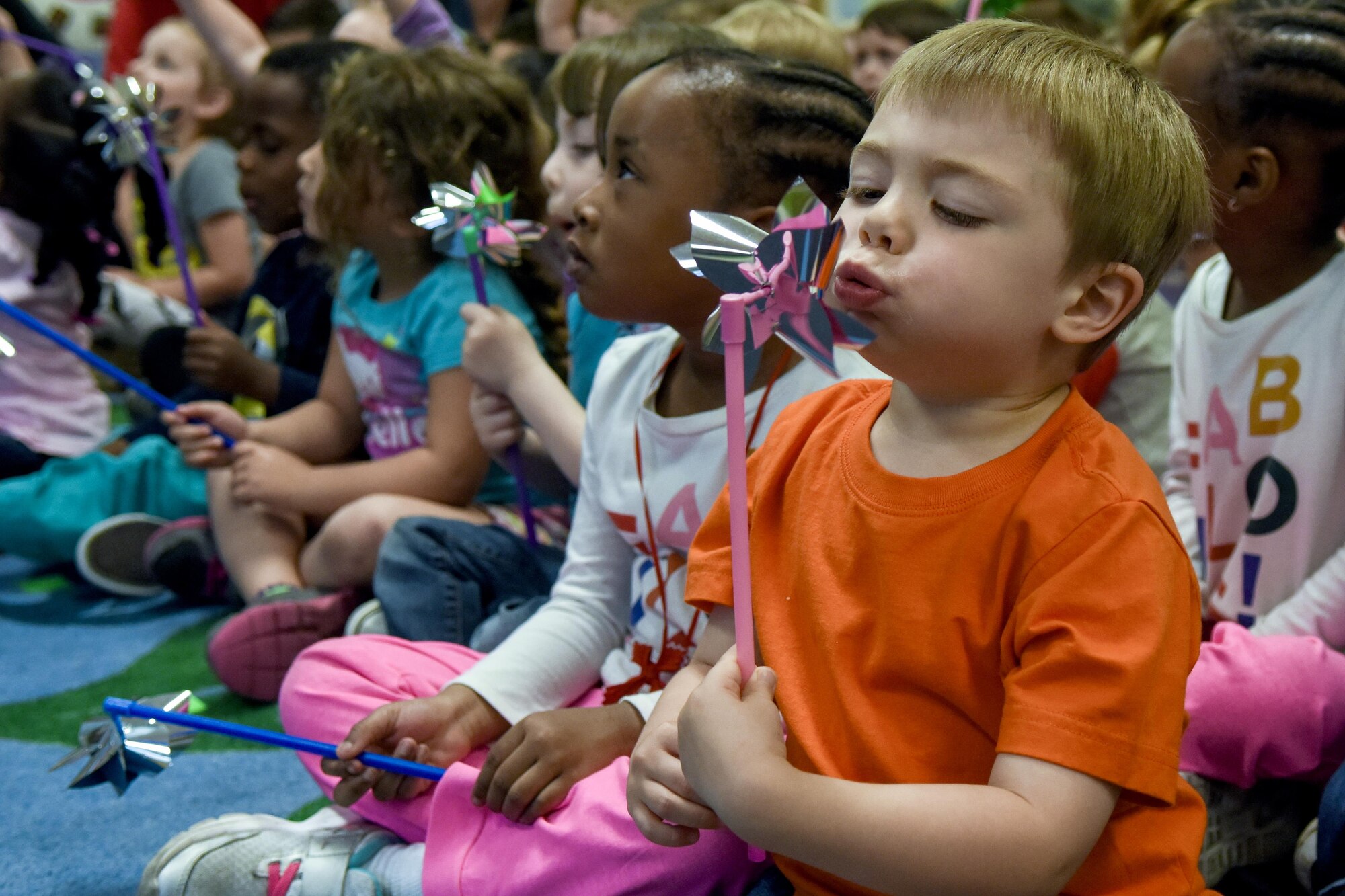 A child of Team Seymour blows on a pinwheel during a “Pinwheels for Child Abuse Prevention” event, April 1, 2016, at Seymour Johnson Air Force Base, North Carolina. The pinwheel become the national symbol for child abuse and neglect prevention in 2008. (U.S. Air Force photo/Airman Shawna L. Keyes)