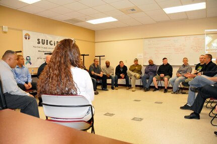 Chap. William Williams and his wife Christine(left foreground) hold a group "intervention circle" during Applied Suicide Intervention Skills Training (ASIST) April 2 at Westover Air Reserve Base, Massachusetts.  The circle allowed for more face-to-face interaction between class participants as they shared stories of loved ones and friends who had taken their own lives.  The training was hosted by the 99th Regional Support Command's Well-Being Program and Services Branch.