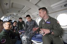 U.S. Air Force Capt. William Poeschl, 459th Airlift Squadron C-12 pilot, briefs Japan Air Self-Defense Force members of the 402nd Squadron during an Aeromedical Evacuation familiarization flight over Yokota Air Base, Japan, March 30, 2016. Members with the 459th AS demonstrated Aeromedical Evacuation operations of a C-12 Huron to JASDF members to improvement the working relationship between JASDF and USAF. (U.S. Air Force photo by Yasuo Osakabe/Released)