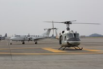 A UH-1 Iroquois and a C-12 Huron, both assigned to the 459th Airlift Squadron, prepare to take off during a training mission at Yokota Air Base, Japan, March 30, 2016. SECOND SENTENCE? (U.S. Air Force photo by Yasuo Osakabe/Released)