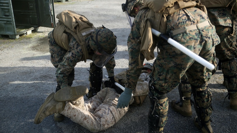 Marines with Combat Logistics Battalion 2 detain a protester during the unit’s non-lethal weapons training final exercise at Camp Lejeune, N.C., March 25, 2016. The battalion had to qualify through the Expeditionary Operations Training Group in preparation for their upcoming deployment with Special Purpose Marine Air-Ground Task Force-Crisis Response-Africa. (U.S. Marine Corps photo by Cpl. Joey Mendez)