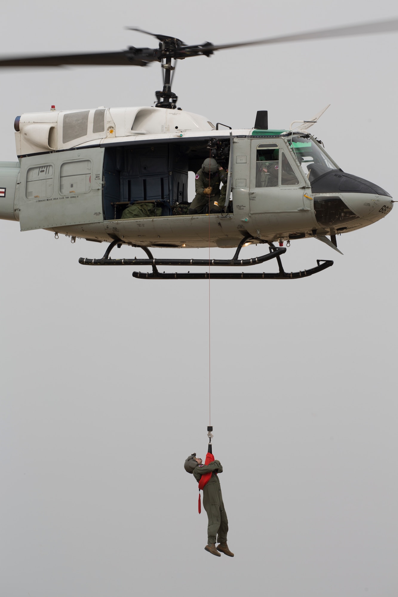 Airmen from the 459th Airlift Squadron perform a hoist demonstration at Yokota Air Base, Japan, March 30, 2016. The 459th AS introduced their airlift capabilities, which were the Aeromedical Evacuation operation with a C-12 Huron and search and rescue capabilities with a UH-1 Iroquois. (U.S. Air Force photo by Yasuo Osakabe/Released)