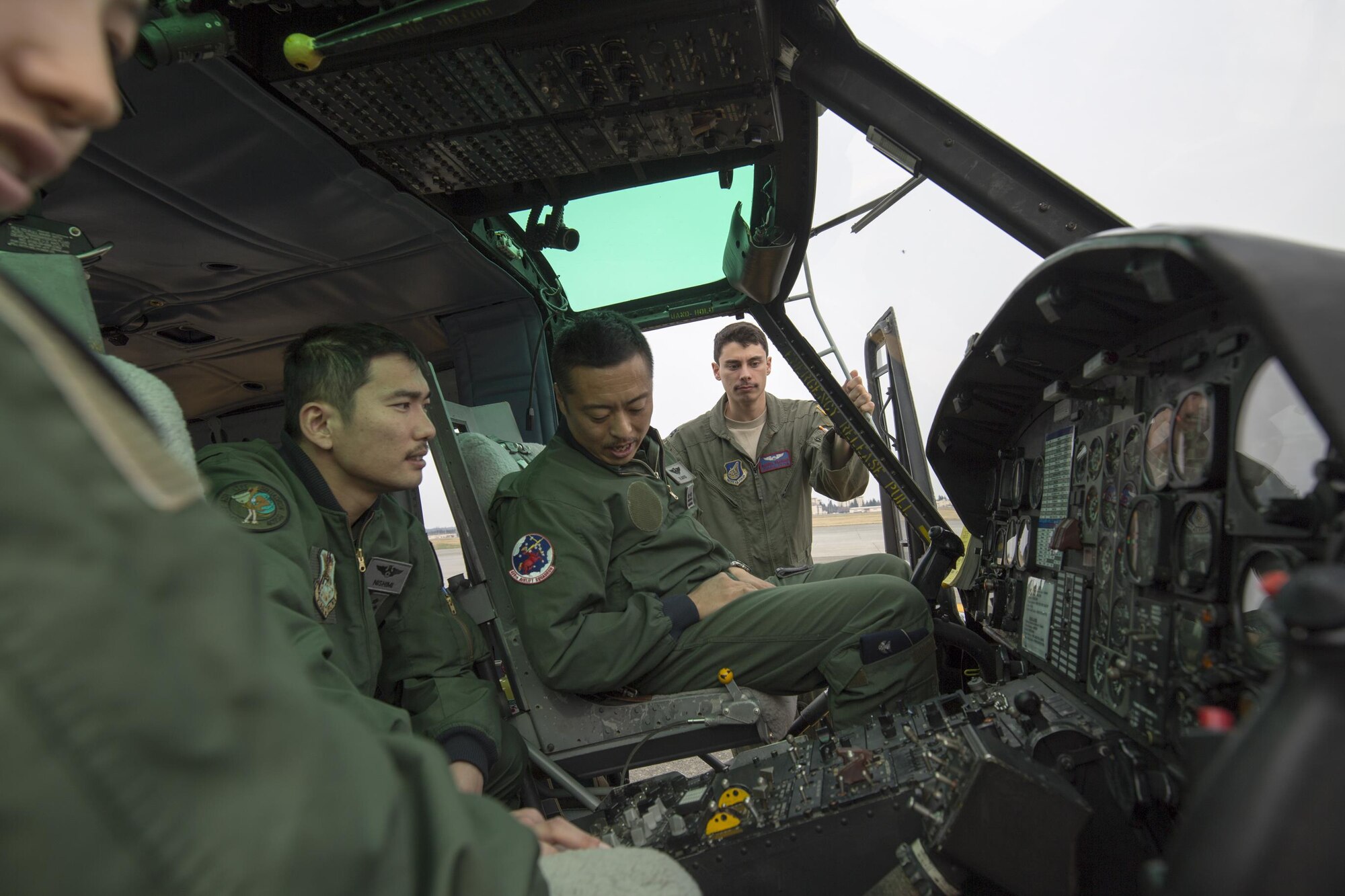 Japan Air Self-Defense members of the 402nd Squadron sit in a UH-1 Iroquois cockpit at Yokota Air Base, Japan, March 30, 2016, during a search and rescue demonstration for 402 SQ members. Members with the 459th AS introduced their airlift capabilities, which were the Aeromedical Evacuation operation with a C-12 Huron and search and rescue capabilities with a UH-1 Iroquois. (U.S. Air Force photo by Yasuo Osakabe/Released)