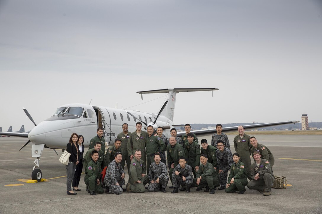 Crew members with the Japan Air Self-Defense Force and U.S. Air Force 459th Airlift Squadron pose for a photo by a USAF C-12 Huron at Yokota Air Base, Japan, March 30, 2016. The 459th AS hosted familiarization flight for members from the 402 SQ to introduce Aeromedical Evacuation operations and demonstrate operating the AE Spectrum Bed. (U.S. Air Force photo by Yasuo Osakabe/Released)