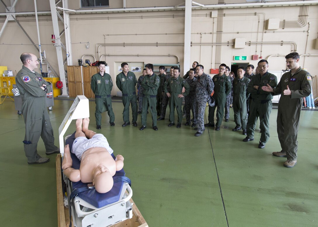 U.S. Air Force Lt. Col. William Martin, right, 459th Airlift Squadron commander, briefs Japan Air Self-Defense Force members of the 402nd Squadron at Yokota Air Base, Japan, March 30, 2016. Airmen from the 459th AS demonstrated Aeromedical Evacuation procedures with a C-12 Huron to JASDF members to improve the working relationship between JASDF and USAF. (U.S. Air Force photo by Yasuo Osakabe/Released)