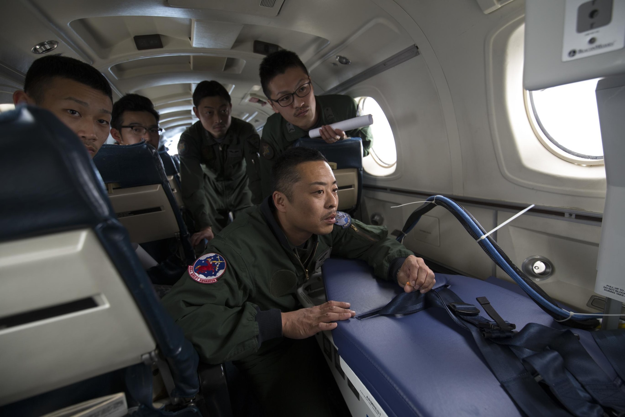 Japan Air Self-Defense Force Lt. Col. Ryoichi Goto, 402nd Squadron commander, checks an Aeromedical Evacuation Bed during an AE familiarization Flight on a C-12 Huron over Yokota Air Base, Japan, March 30, 2016. Members with the 459th AS demonstrated Aeromedical Evacuation procedures of a C-12 Huron to JASDF members to improve the working relationship between JASDF and USAF. (U.S. Air Force photo by Yasuo Osakabe/Released)