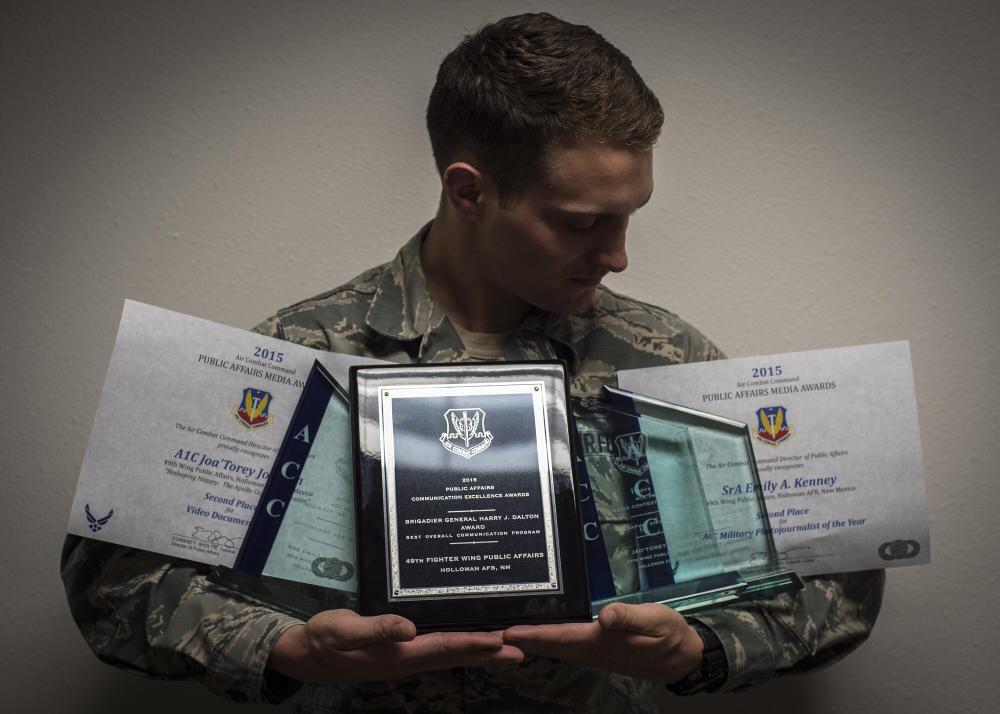 Airman 1st Class Randahl Jenson, a 49th Wing Public Affairs photojournalist, holds various media awards currently won by photojournalists and broadcasters from the 49th Wing Public Affairs office, April 4 at Holloman Air Force Base, N.M. Six of Holloman’s highest performers who were honored with Air Combat Command or Secretary of the Air Force-level awards for their efforts throughout 2015. 