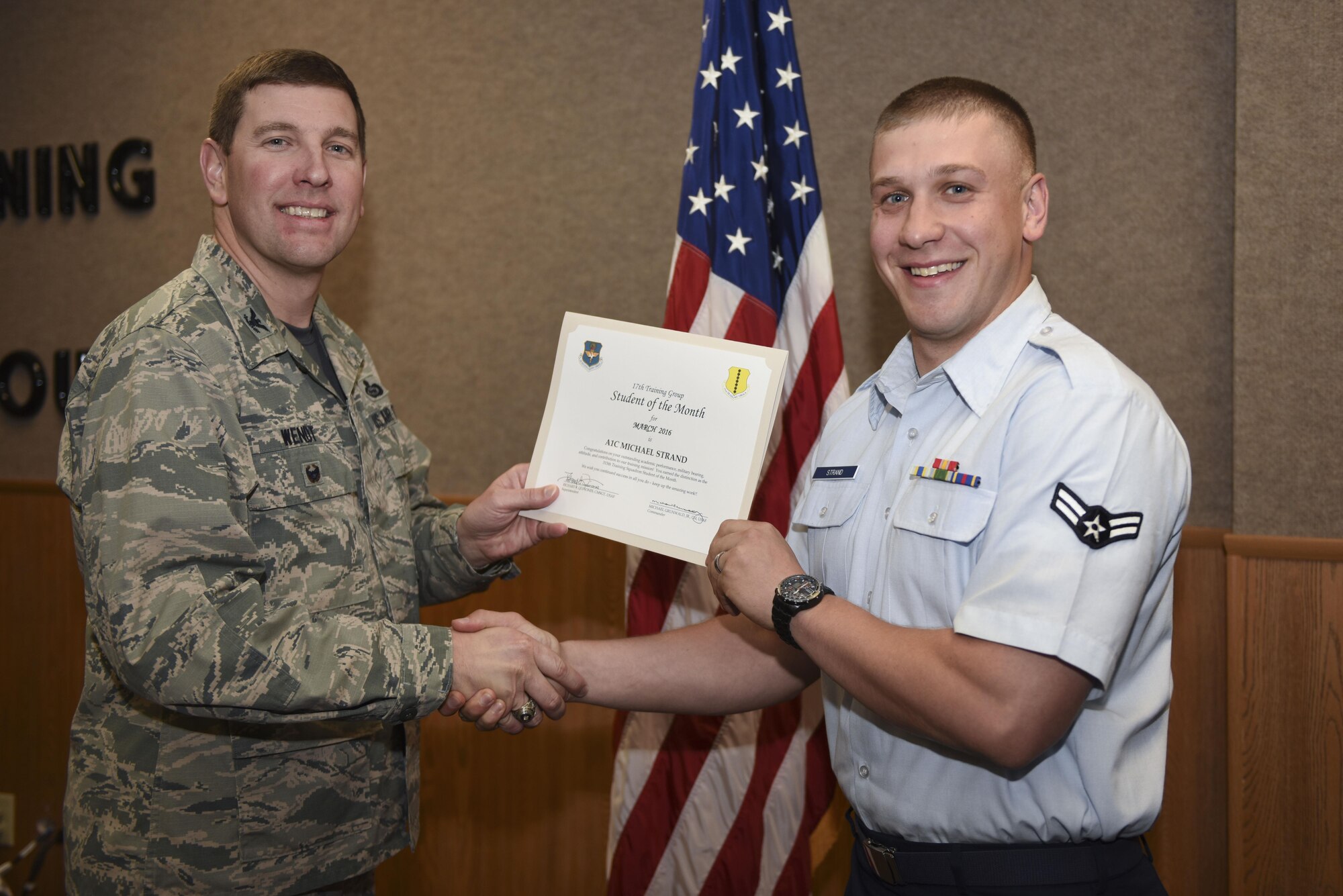 U.S. Air Force Col. Kurt A. Wendt, 17th Training Group Deputy Commander, presents the 315th Training Squadron Enlisted Student of the Month award for March 2016 to Airman 1st Class Michael Strand at the Brandenburg Hall on Goodfellow Air Force Base, Texas, April 1, 2016. (U.S. Air Force photo by Airman Chase Sousa/Released)