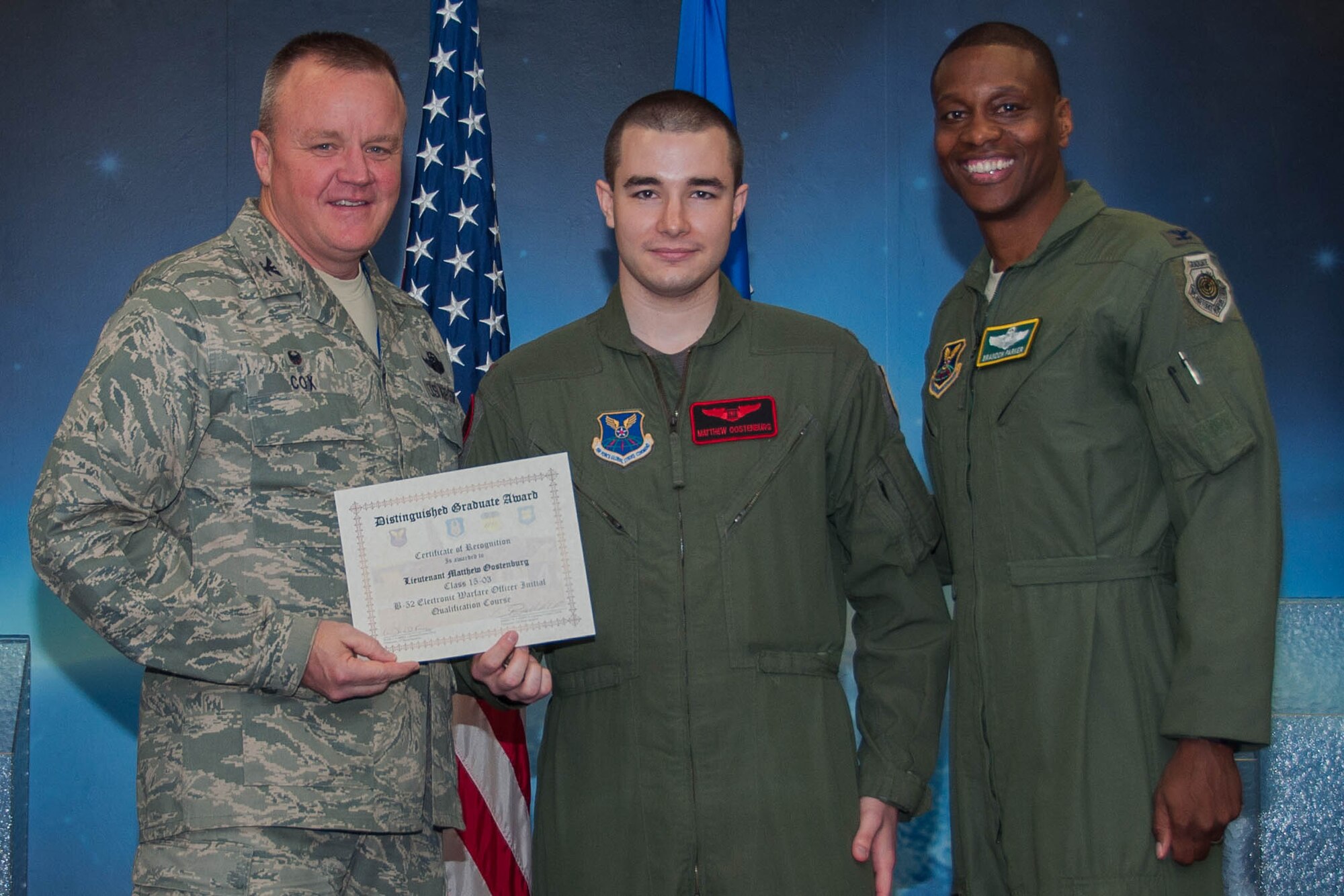 U.S. Air Force, Col. Bruce Cox, commander of the 307th  Bomb Wing and Col. Brandon Parker, vice commander of the 2nd Bomb Wing, present the Electronic Warfare Officer Distinguished Graduate Award to 2nd Lt. Matthew Oostenburg during a Formal Training Unit (FTU) graduation ceremony, April 1, 2016, Barksdale Air Force Base, La. Nelles graduated from the FTU as an Electronic Warfare Officer on the B-52H Stratofortress. (U.S. Air Force photo by Master Sgt. Laura Siebert /Released)