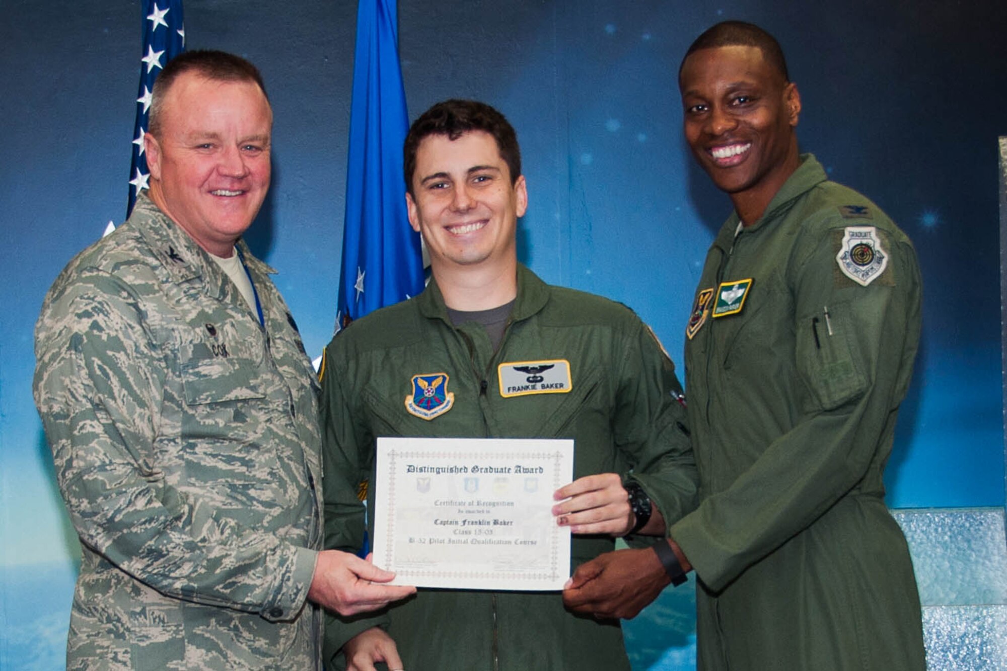 U.S. Air Force, Col. Bruce Cox , commander of the 307th  Bomb Wing and Col. Brandon Parker, vice commander of the 2nd Bomb Wing, present the Pilot Distinguished Graduate Award to Capt. Franklin Baker during a Formal Training Unit (FTU) graduation ceremony, April 1, 2016, Barksdale Air Force Base, La. Baker graduated from the FTU as a pilot on the B-52H Stratofortress. (U.S. Air Force photo by Master Sgt. Laura Siebert /Released)