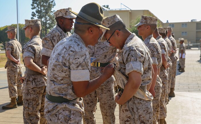 Staff Sgt. James H. Corpin, Kilo Company, 3rd Recruit Training Battalion, inspects a recruit’s web belt and blouse during a series commander inspection at Marine Corps Recruit Depot San Diego, April 4. Recruits are given classes on uniform standards and are expected to maintain those standards throughout training. Annually, more than 17,000 males recruited from the Western Recruiting Region are trained at MCRD San Diego. Kilo Company is scheduled to graduate May 6.