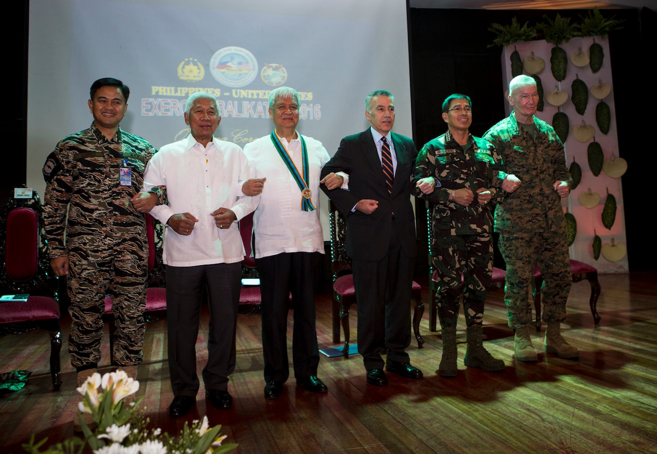 The official party including government officials and military leaders from the Armed Forces of the Philippines and United States, stand together for a photo at the opening ceremony of Balikatan 2016, aboard Camp Aguinaldo, April 4, 2016. Balikatan, which means "shoulder to shoulder" in Filipino, is an annual bilateral training exercise focused on improving the ability of Philippine and U.S. military forces to work together during planning, contingency and humanitarian assistance and disaster relief operations. This year marks the 32nd iteration of the exercise. (U.S. Marine Corps photo by Sgt. Erik Estrada)