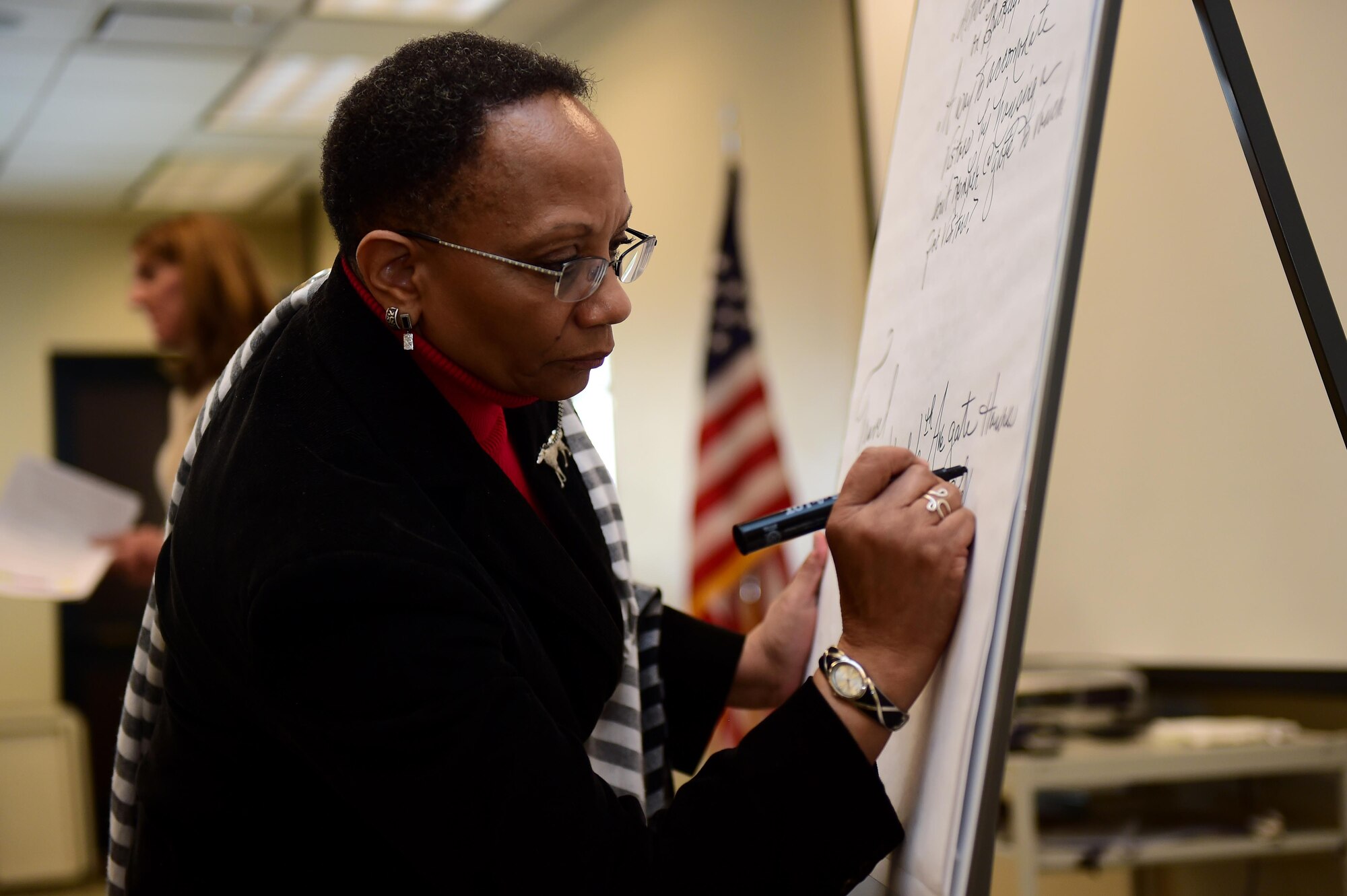 Peggy Moore-McCoy, 460th Space Wing Sexual Assault Response Coordinator, writes down relevant topics March 28, 2016, during a Caring for People forum at the Chapel on Buckley Air Force Base, Colo. During the forum, active-duty, guard and reserve Service members, family members, retirees and civilians discussed topics such as health and wellness or family and spouse support. (U.S. Air Force photo by Airman 1st Class Gabrielle Spradling/Released)
