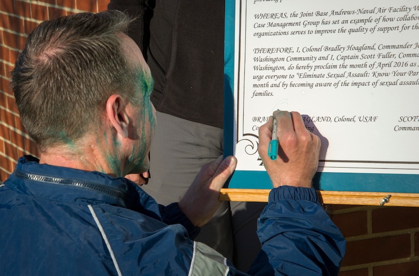 Col. Brad Hoagland, 11th Wing/Joint Base Andrews commander, signs a proclamation after the second annual “Consent to Color” 5k run here, April 4, 2016. The event signified the recognition of April as Sexual Assault Awareness Month. (U.S. Air Force photo by Senior Airman Ryan J. Sonnier/RELEASED)
