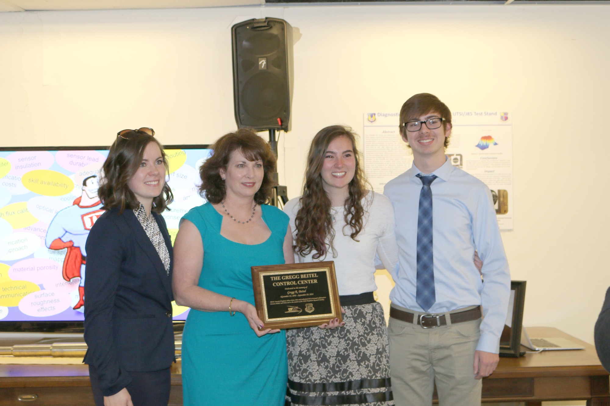 At the dedication ceremony March 18 at UTSI, the Beitel Family pose with a plaque in honor of Gregg Beitel, ATA engineer who worked at AEDC for more than 30 years before his passing in September 2014. Beitel helped in spearheading the Propulsion Research Facility at UTSI. The control room for the facility has been named the Gregg Beitel Control Center in his honor and the plaque will be mounted at the entrance of the building. Pictured left to right: Beitel’s daughter Natalie, wife Myra, daughter Hayley and son Roscoe. (U.S. Air Force photo/Deidre Ortiz)