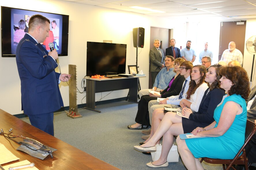 During a dedication ceremony March 18 at the Propulsion Research Facility control room at University of Tennessee Space Institute, Col. Timothy West, AEDC Test Operations Division Chief, presents military coins to the family members of the late Gregg Beitel, ATA engineer. Beitel worked at AEDC more than 30 years. (U.S. Air Force photo/Deidre Ortiz)