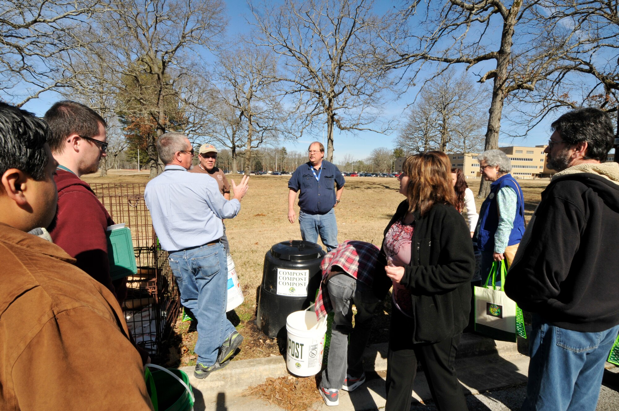 Green Team captains gather Feb. 6, 2015 at compost bins that are placed throughout the AEDC industrial area to receive instructions on taking care of the bins. The AEDC compost program began last year as part of an Air Force grant. By composting food scraps and hand towel wastes, AEDC will divert as much as six tons of material per year from being sent to the landfill. (U.S. Air Force photo/Jacqueline Cowan)