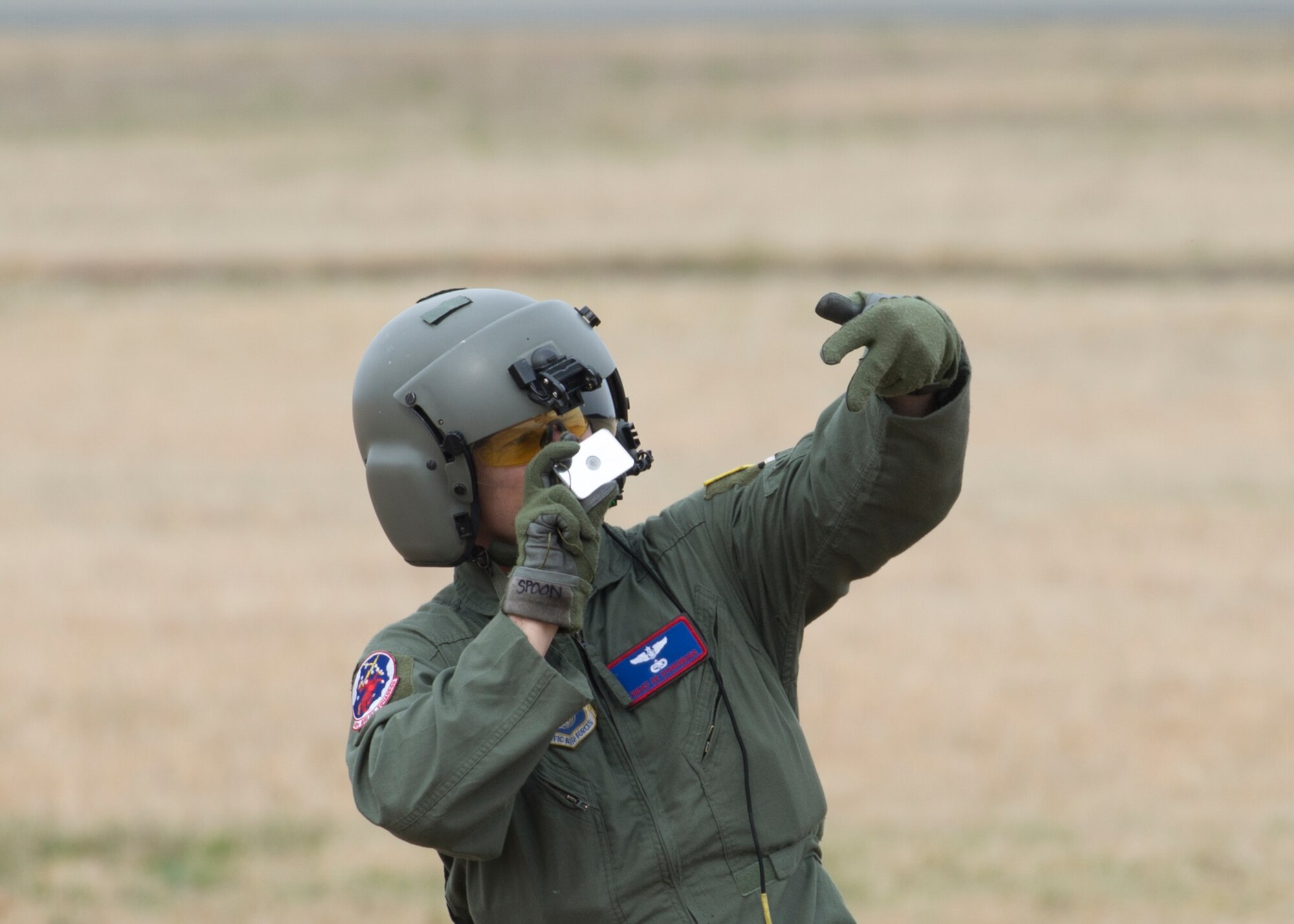 Senior Master Sgt. Edward Sponenburg, 459th Airlift Squadron superintendent, uses a signal mirror to coordinate a landing zone with a UH-1 Iroquois pilot at Yokota Air Base, Japan, March 30, 2016. 459 AS members introduced their airlift capabilities, which were the Aeromedical Evacuation operation with a C-12 Huron and search and rescue capabilities with a UH-1 Iroquois. (U.S. Air Force photo by Yasuo Osakabe/Released)