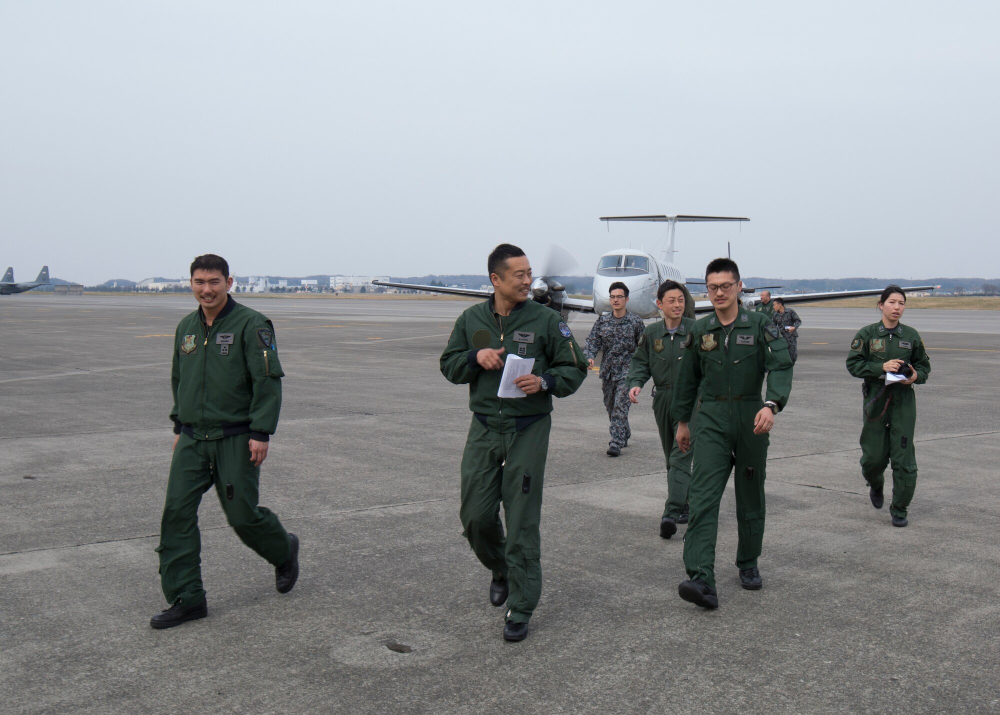 Japan Air Self-Defense Force members walk on the flightline after completing an Aeromedical Evacuation familiarization flight with a C-12 Huron at Yokota Air Base, Japan, March 30, 2016. 459 AS members demonstrated Aeromedical Evacuation operations of a C-12 Huron to JASDF members to improve the working relationship between JASDF and USAF. (U.S. Air Force photo by Yasuo Osakabe/Released)