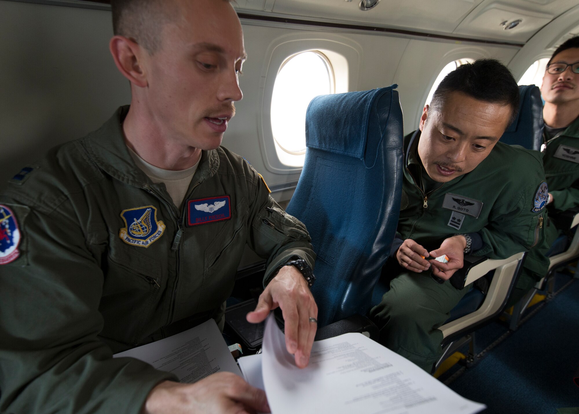 (Left to right) U.S. Air Force Capt. William Poeschl, 459th Airlift Squadron C-12 pilot talks about Aeromedical Evacuation procedures of a C-12 Huron to Japan Air Self-Defense Force Lt. Col. Ryoichi Goto, 402nd Squadron commander, during AE familiarization flight at Yokota Air Base, Japan, March 30, 2016. 459 AS members demonstrated Aeromedical Evacuation procedures of a C-12 Huron to JASDF members to improve the working relationship between JASDF and USAF. (U.S. Air Force photo by Yasuo Osakabe/Released)