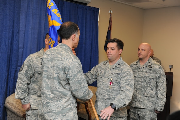 Lt. Col. Patrick Cox (right) relinquishes command of the 274th Air Support Operations Squadron (ASOS) to Col. Michael Comella, 152nd Air Operations Group commander, during a change of command ceremony at Hancock Field Air National Guard Base April 3. (U.S. Air National Guard photo by Tech. Sgt. Justin A. Huett/Released)