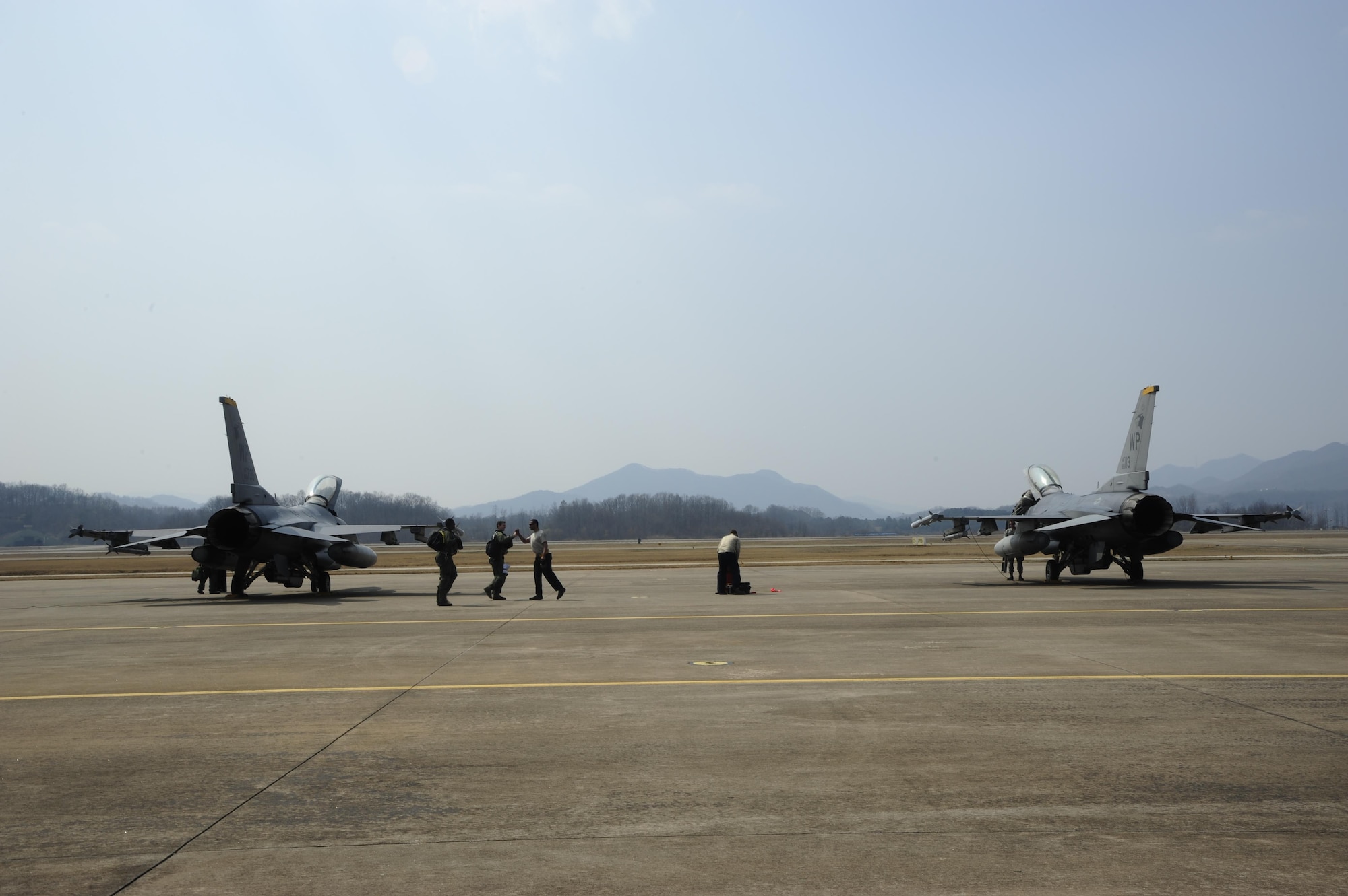 Airmen from the 80th Aircraft Maintenance Unit and pilots from the 80th Fighter Squadron greet one another before a post-flight inspection during Buddy Wing 16-3 at Jungwon Air Base, Republic of Korea, March 30, 2016. Buddy Wing training, held multiple times a year, polishes the ability of the Republic of Korea air force and U.S. Air Force Airmen to train and operate as a combined force. (U.S. Air Force photo by Staff Sgt. Nick Wilson/Released)