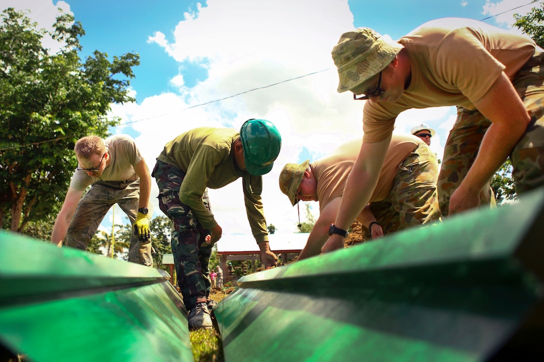 Air Force Airman 1st Class Jeremy Clapham, left, Philippine Army Pfc. Ramie Villacampa, center, and Scott Nolan, an Australian service member, paint gutters during Balikatan 2016 at Jaena Norte Elementary School in Capiz, Philippines, April 2, 2016. Clapham is assigned to the 673rd Expeditionary Civil Engineer Squadron, Villacampa is assigned to 552 Engineer Construction Battalion and Nolan is assigned to 6th Engineer Support Regiment. Marine Corps photo by Cpl. Hilda M. Becerra