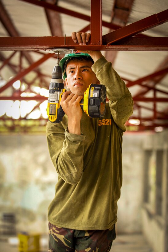 Philippine Army Pvt. Robert Abgao drills a base for a ceiling fan during Exercise Balikatan 2016 at Jaena Norte Elementary School in Capiz, Philippines, April 2, 2016. Abago is assigned to the 552 Engineer Construction Battalion. Marine Corps photo by Cpl. Hilda M. Becerra