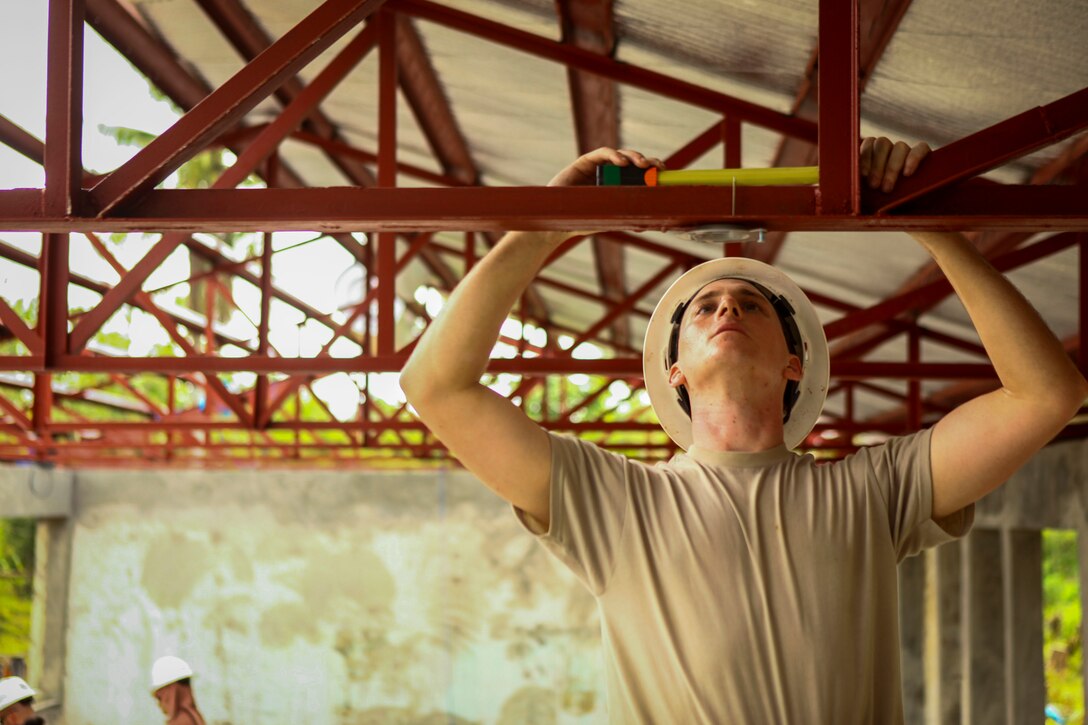 An airman measures a specific distance to install a ceiling fan during Exercise Balikatan 2016 at Jaena Norte Elementary School in Capiz, Philippines, April 2, 2016. Marine Corps photo by Cpl. Hilda M. Becerra
