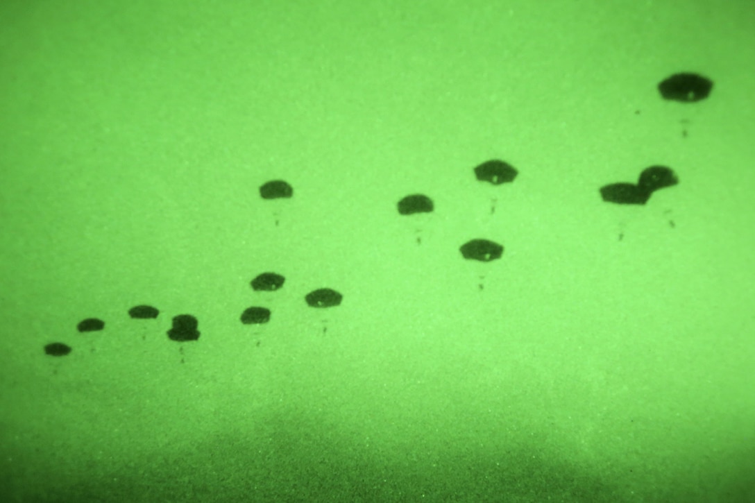 As seen through a night-vision device, paratroopers participate in a night airborne operation onto Malemute drop zone at Joint Base Elmendorf-Richardson, Alaska, March 31, 2016. The paratroopers are assigned to the 25th Infantry Division’s 4th Brigade Combat Team (Airborne). Air Force photo by Alejandro Pena