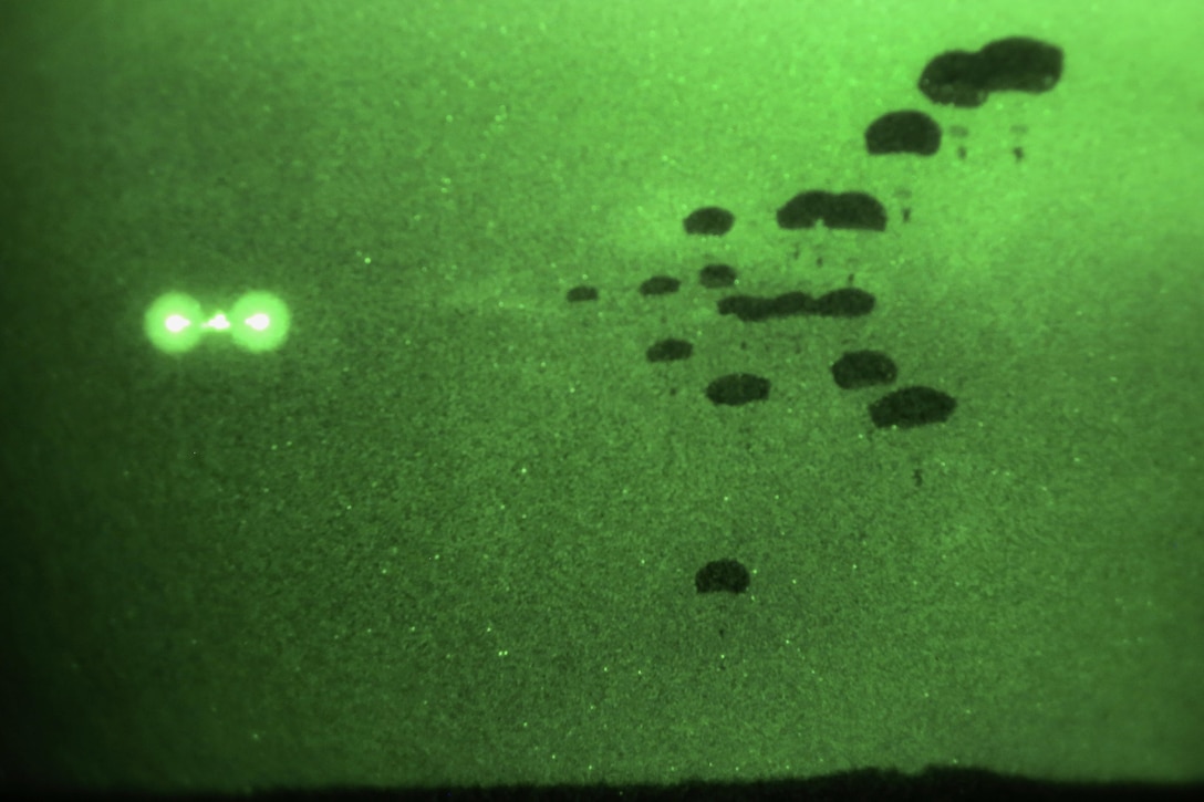 As seen through a night-vision device, paratroopers participate in a night airborne operation onto Malemute drop zone at Joint Base Elmendorf-Richardson, Alaska, March 31, 2016. Air Force photo by Alejandro Pena