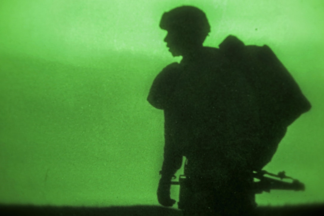 As seen through a night-vision device, a paratrooper proceeds to a rally point after participating in a night airborne operation onto Malamute drop zone at Joint Base Elmendorf-Richardson, Alaska, March 31, 2016. Air Force photo by Alejandro Pena