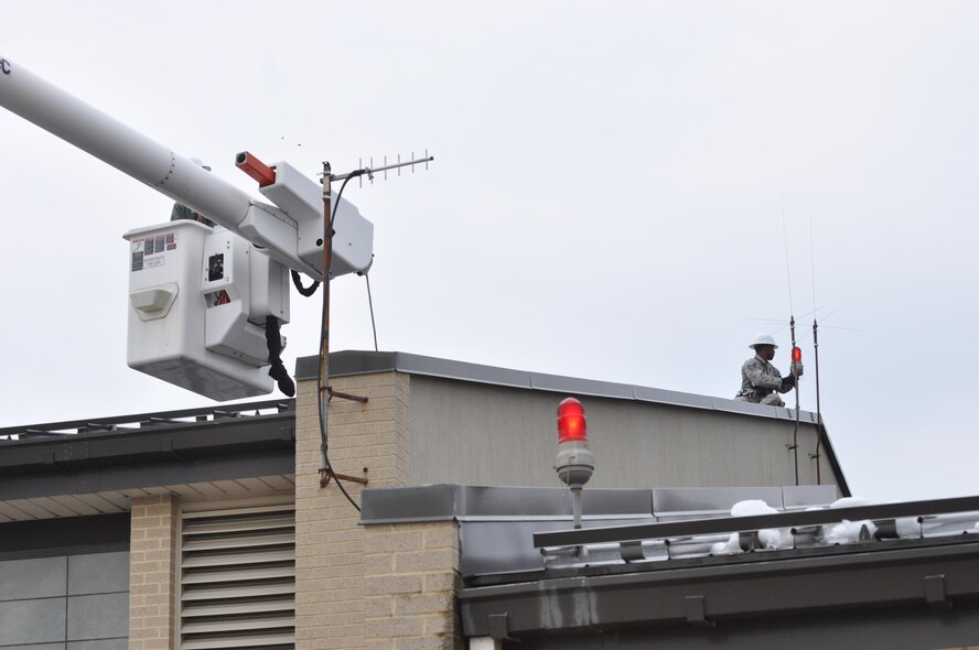 Staff Sgt. Terrill Strothers, 512th Civil Engineer Squadron electrical technician, inspects the signal lights on the roof of the base firehouse March 6, 2016 at Dover Air Force Base, Del. Part of the upgrade training for Air Force Reserve electrical technicians is operating the bucket truck (U.S. Air Force photo/Staff Sgt. Joe Yanik)