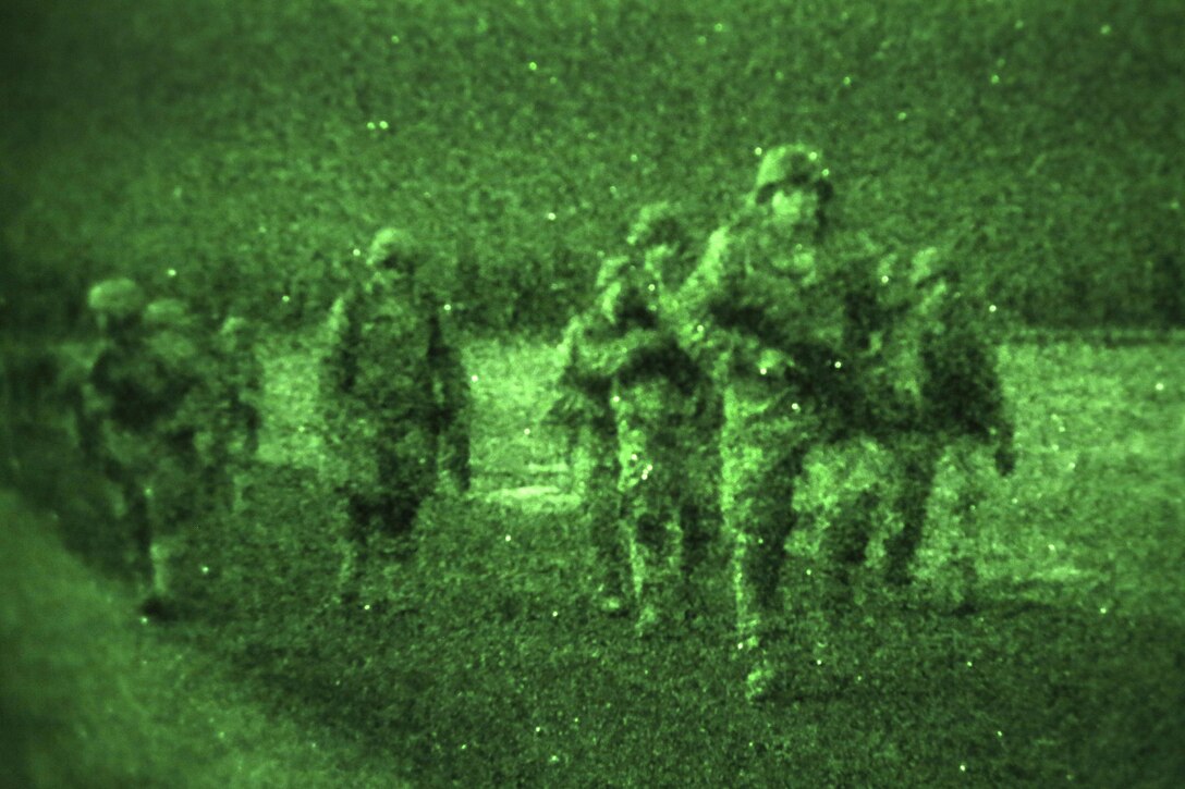 As seen through a night-vision device, paratroopers proceed to the rally point after participating in a night airborne operation onto Malemute drop zone at Joint Base Elmendorf-Richardson, Alaska, March 31, 2016. Air Force photo by Alejandro Pena