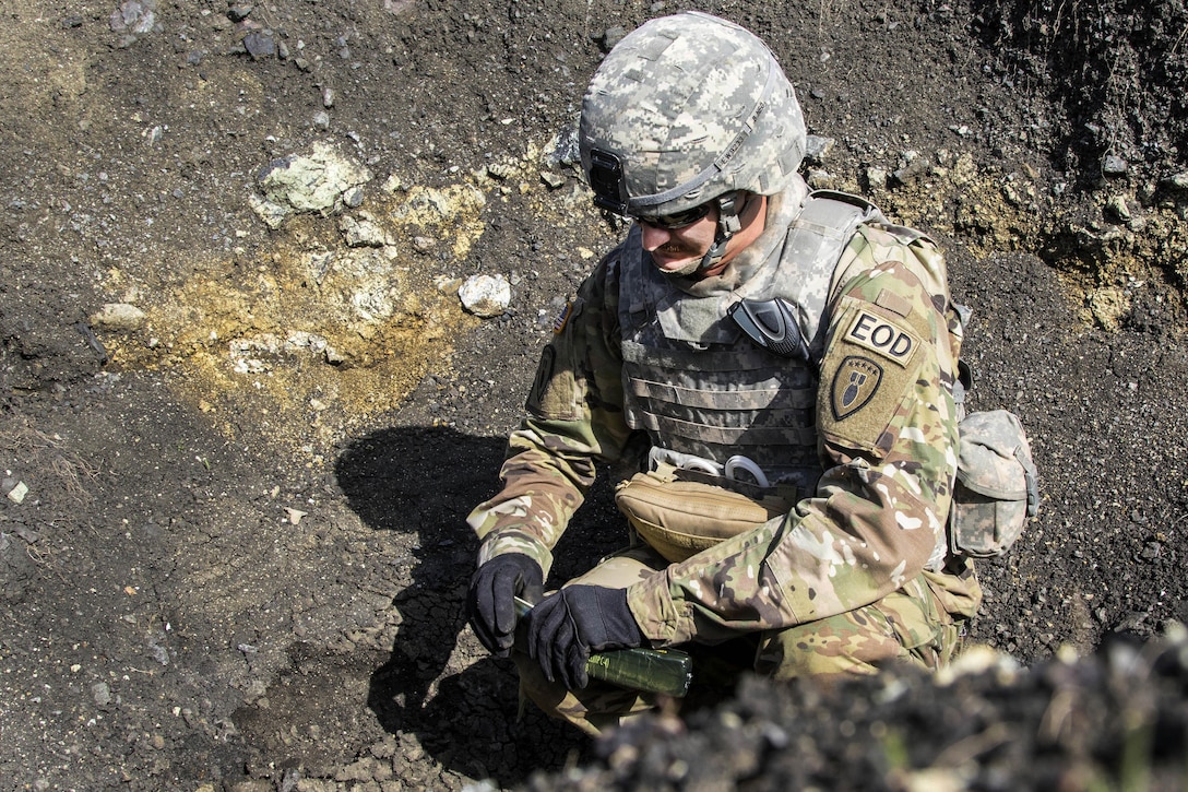 U.S. Army Sgt. Eric Wallace places C4 explosives onto a stack of unexploded ordnances during a joint mine clearing operation at Orahovac Demolition Range in Kosovo, April 4, 2016. Wallace is an explosive ordnance disposal technician assigned to the Multinational Battle Group-East. Army photo by Staff Sgt. Thomas Duval