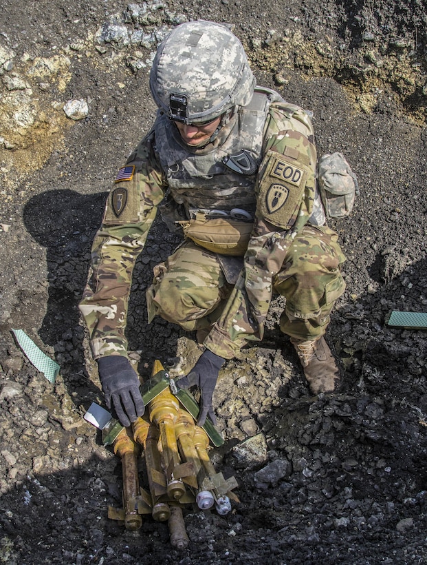 U.S. Army Sgt. Eric Wallace places C4 explosives onto a stack of unexploded ordnances during a joint mine clearing operation at Orahovac Demolition Range in Kosovo, April 4, 2016. Wallace is an explosive ordnance disposal technician assigned to the Multinational Battle Group-East. Army photo by Staff Sgt. Thomas Duval
