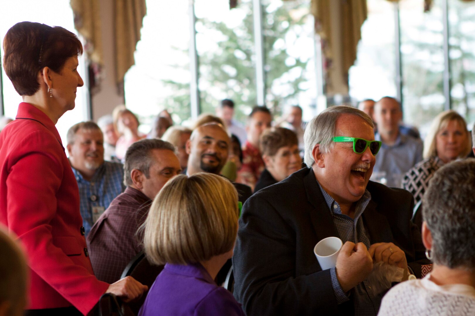 John Kurtz is presented gifts from coworker Lori Lucius, far left, at a March 17 retirement ceremony. 