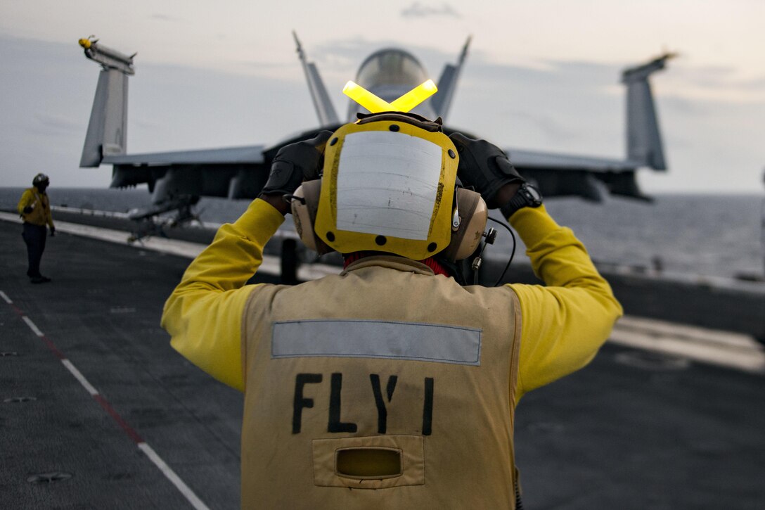 Navy Petty Officer 2nd Class Keyonnia Cook directs an F/A-18F Super Hornet assigned to Strike Fighter Squadron 32 on the flight deck of the aircraft carrier USS Dwight D. Eisenhower in the Atlantic Ocean, March 24, 2016. Cook is an aviation boatswain’s mate, handling. Navy photo by Seaman Nathan Bear