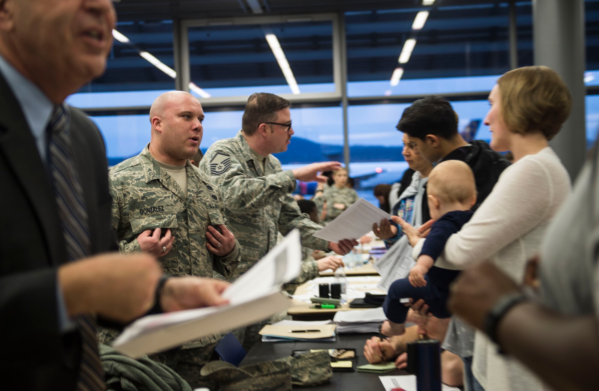 Airmen from the 86th Airlift Wing process families into Ramstein Air Base, Germany, after their departure from Turkey on March 30, 2016. Because of the ongoing threat in the region, dependents of service members were ordered to leave Turkey and Ramstein AB was designated as a “transition location” for families to await travel to their subsequent duty locations. However, a number of families will relocate to Ramstein AB for an extended period of time. (U.S. Air Force photo/Staff Sgt. Sara Keller)
